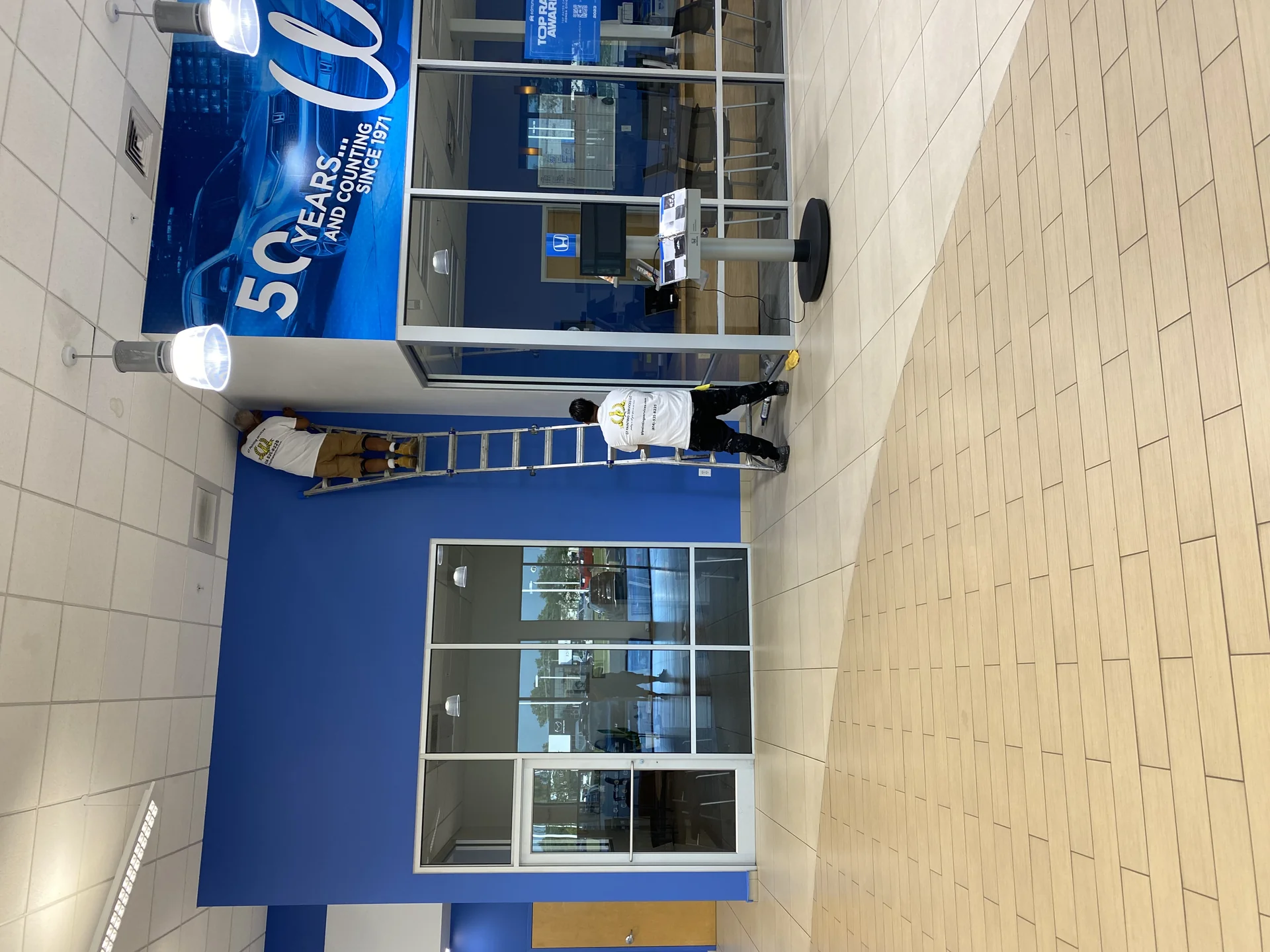 Crew painting inside a Honda dealership showroom