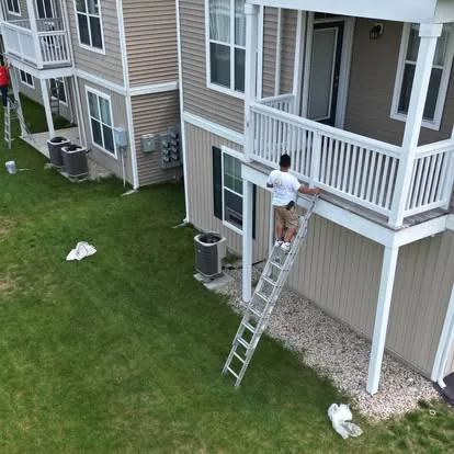 Painter working on an apartment balcony railing
