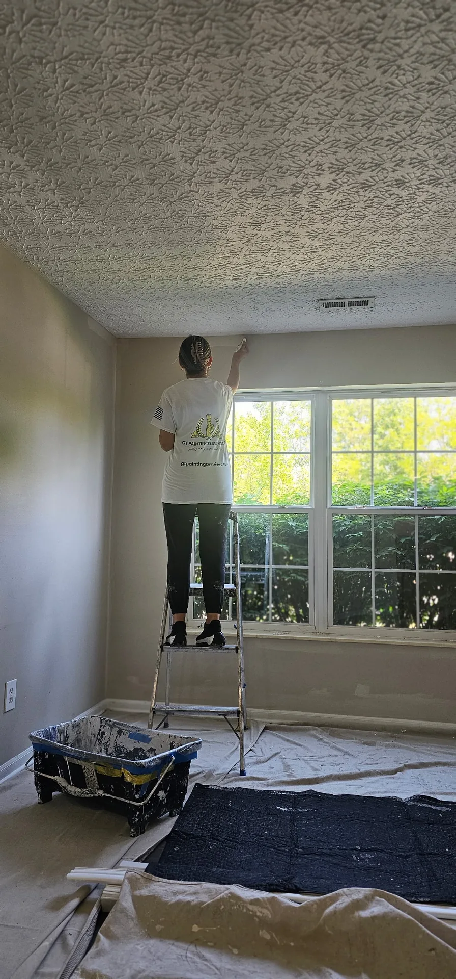 GT Painting Services crew member carefully cutting in a ceiling line